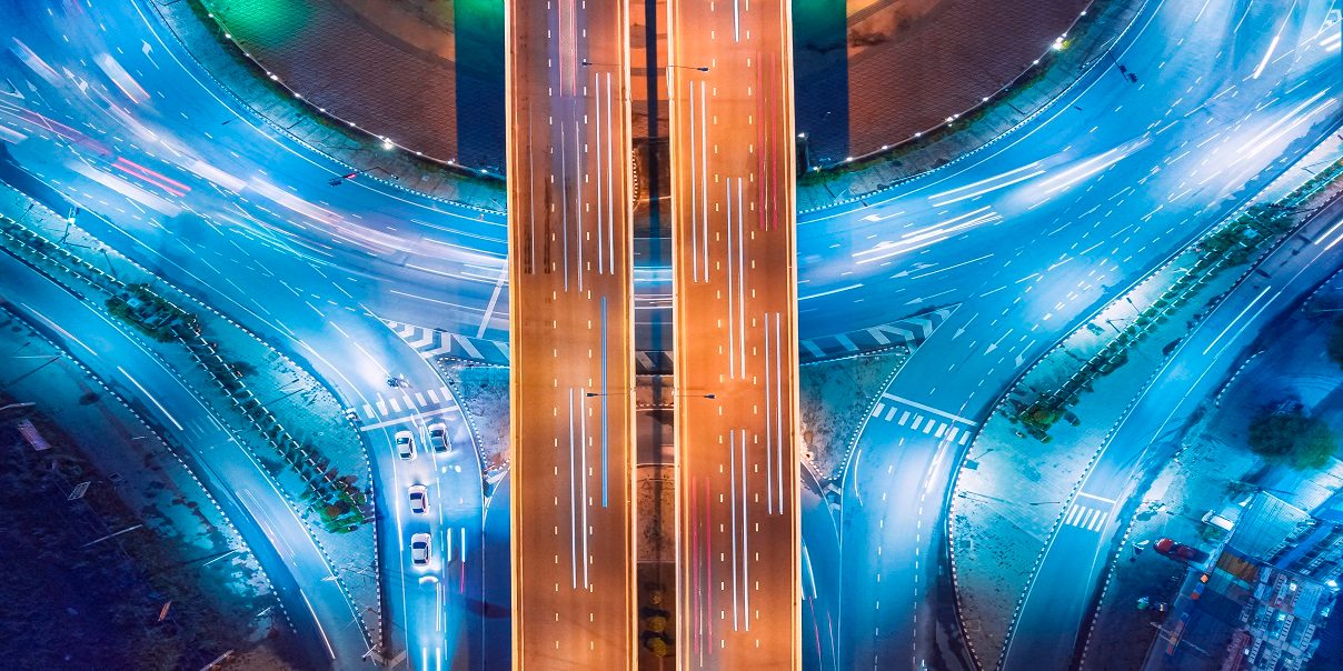 Aerial top view of roads, highways, traffic or circles for transportation at night in Thailand or futuristic concepts.