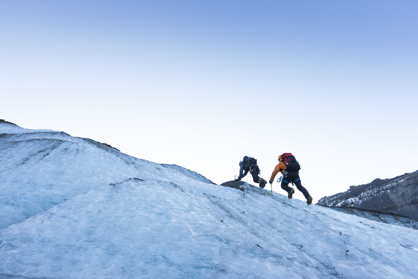 Two men climbing up snow mountain 