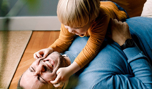 Boy holding dad's cheeks