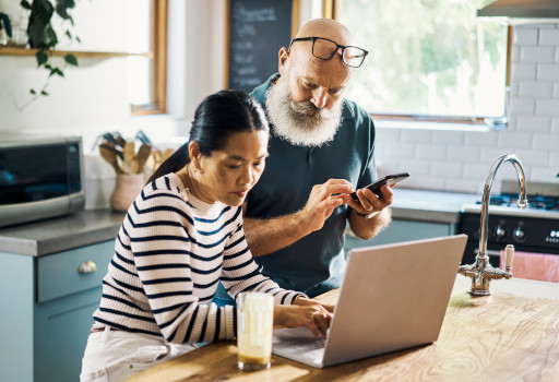 couple looking at laptop and phone