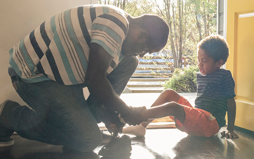 Man tying boy's shoolaces