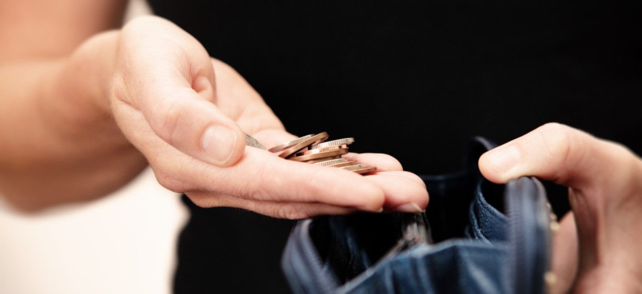 Woman with coins in hand with black leather purse