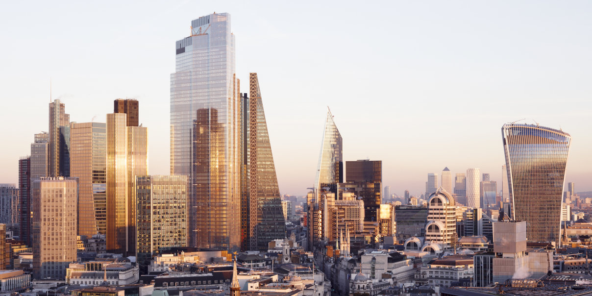 UK, London, looking East from high up with view of high rise office buildings and Canary wharf against clear sky at sunset
